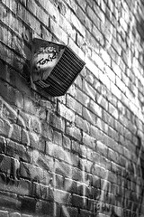 Moody brick building exterior with vent tall view