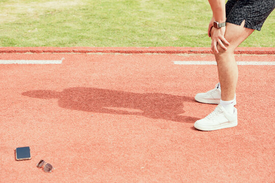 Man resting after jogging in a sunny park