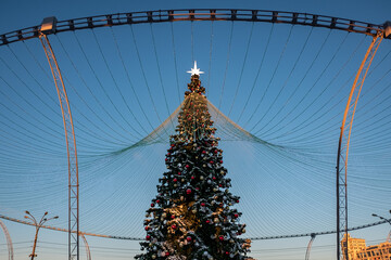 Christmas tree and New Year decorations on the town square on a frosty winter day.