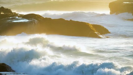 Powerful ocean waves crashing against sunlit rocky cliffs at sunset water - Powered by Adobe