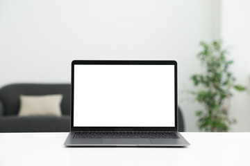Fototapeta premium Laptop on white desk indoors. Mockup for design