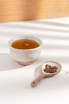 Herbal tea in ceramic cup with loose leaves