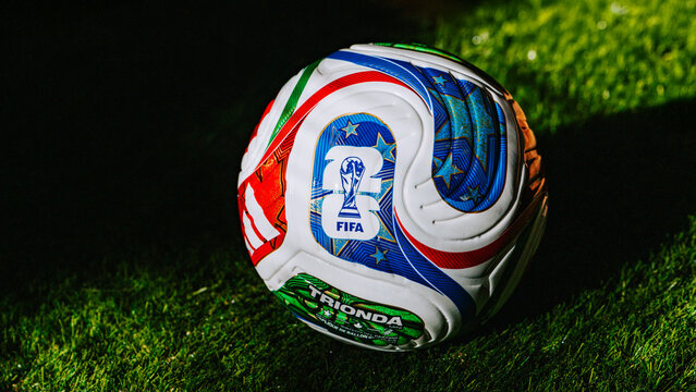 Official Trionda football with the FIFA World Cup 2026 logo resting on green grass &mdash; symbol of the tournament in the USA, Mexico, and Canada. Panorama format.
