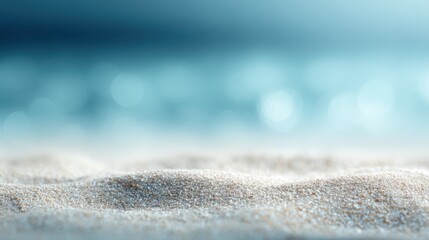 Summer beach scene, sand in sharp focus with blurred sea and sky. Space for text or product illustration