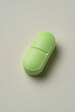 Green pill on a white surface