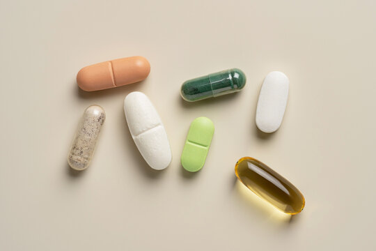 Various colorful pills on beige background