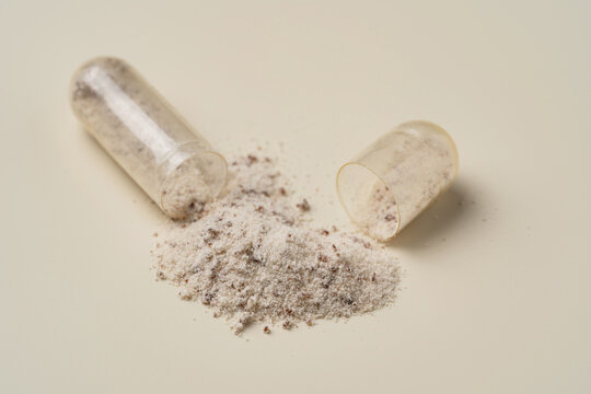 Open transparent capsule with spilled powder supplement