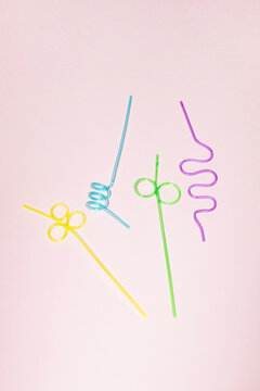 Colorful and twisted drinking straws on pink background