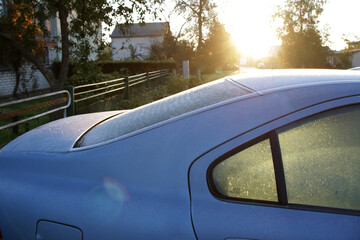 frost on car window and bright dazzle morning sunlight