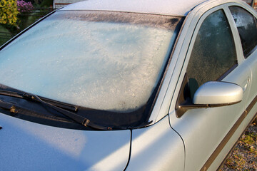 frost on car window and bright dazzle morning sunlight