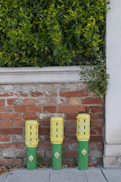 Protected water outlets along a brick wall for public use