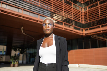 Confident businesswoman standing outdoors in sunlight