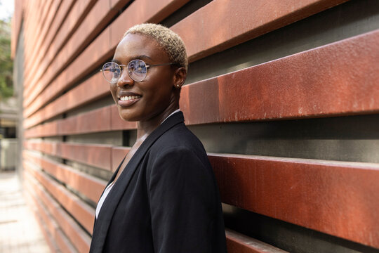 Businesswoman smiling confidently against the wall