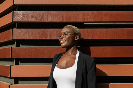 Confident businesswoman standing against wooden wall