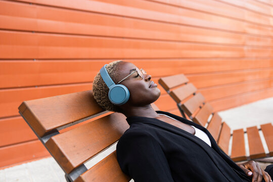 Businesswoman relaxing with headphones outdoors