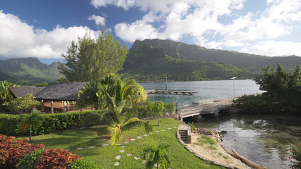 Fototapeta premium Luxury resort photo of Moorea paradise islands with tropical trees. Photography with ocean, sky with clouds. French Polynesia. Pacific Ocean.