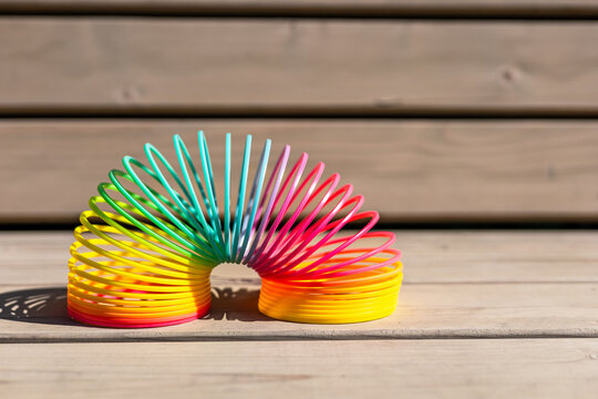 Rainbow-colored magic spring on wooden surface