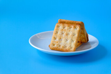 Crispy crackers or biscuits in white dish .
