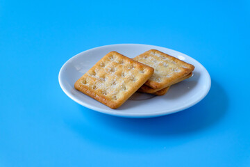 Crispy crackers or biscuits in white dish .