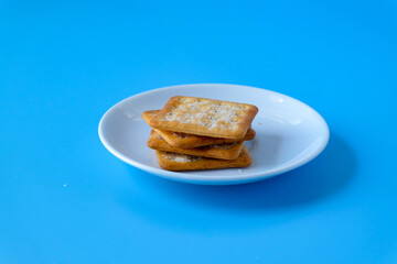 Crispy crackers or biscuits in white dish .