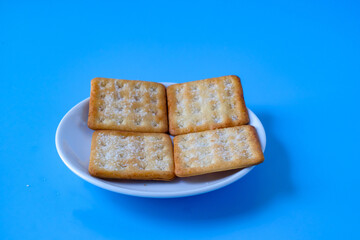 Crispy crackers or biscuits in white dish .