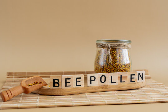 Natural bee pollen in jar on beige textured background