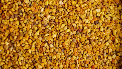Bee pollen granules on beige background for natural energy