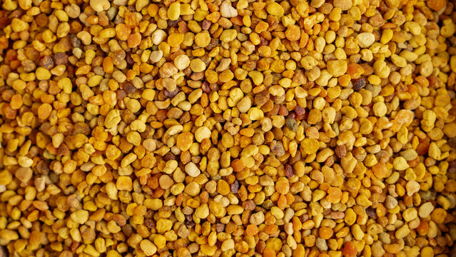 Bee pollen granules on beige background for natural energy