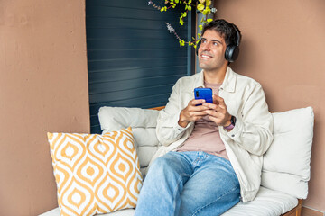 Hispanic man relaxing listening to music with headphones