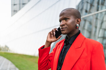Young man in red jacket using smartphone outdoors