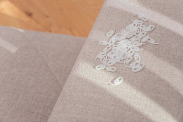 Samples of bright colored fabrics and white hooks for curtains close-up