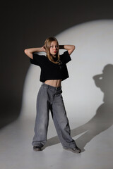 Young caucasian female posing in studio with shadows and contrast lighting