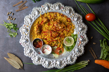 Chicken Mixed Khichuri on a Silver Thali Platter with Raita and Side Salad in plate top view of bangladeshi food