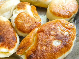 Fried flour pie in a pan. Dough pies, home cooking. Making dough pies, frying in oil, close-up.