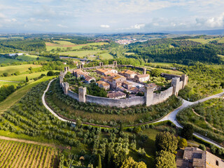 Monteriggioni, Tuscany, Italy - aerial view of the medieval village surrounded by a wall among vines and olive trees