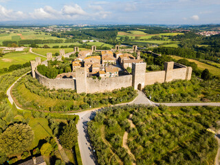 Monteriggioni, Tuscany, Italy - aerial view of the medieval village surrounded by a wall among vines and olive trees