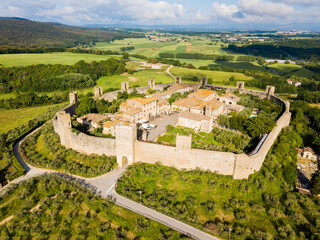 Monteriggioni, Tuscany, Italy - aerial view of the medieval village surrounded by a wall among vines and olive trees