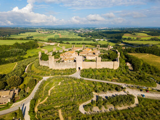 Monteriggioni, Tuscany, Italy - aerial view of the medieval village surrounded by a wall among vines and olive trees
