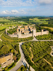 Monteriggioni, Tuscany, Italy - aerial view of the medieval village surrounded by a wall among vines and olive trees
