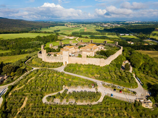 Monteriggioni, Tuscany, Italy - aerial view of the medieval village surrounded by a wall among vines and olive trees