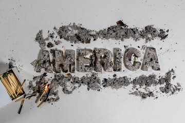 The word America lies burned and charred against white seamless