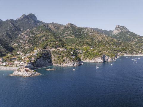 Aerial view of the dramatic coastline where the village meets the Tyrrhenian Sea under the gaze of rugged mountains, Erchie, Amalfi Coast, Campania, Italy.