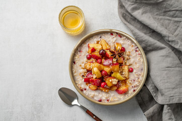 Overnight oatmeal with apples, cranberries, and cinnamon in a bowl on a light background