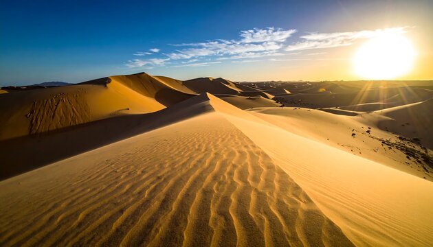 The sun sets over rolling, rippled sand dunes in a vast desert landscape