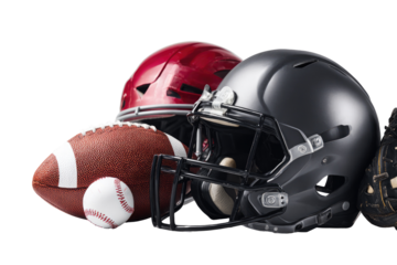 Close-up of football helmets and balls.  Red and black football helmets, a football, and a baseball sit together