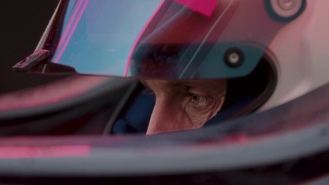 Close-up of a focused pilot driver in a red racing car preparing for a race