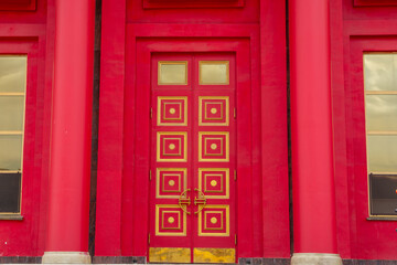Fototapeta premium Majestic entrance to Buddhist temple with red pillars. Symmetric architecture and golden design