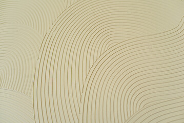 Beige textured background with abstract curved pattern of plaster or putty