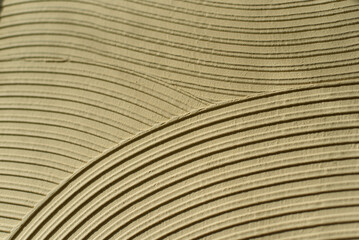 Beige textured background with abstract curved pattern of plaster or putty