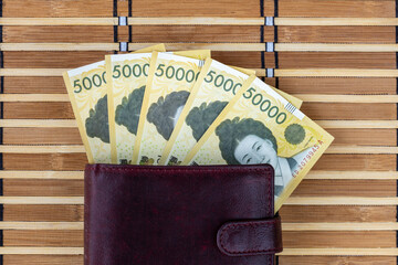 South Korean money. 50,000 won bills sticking out of a wallet. The currency is KRW. Business and financial concept. close up